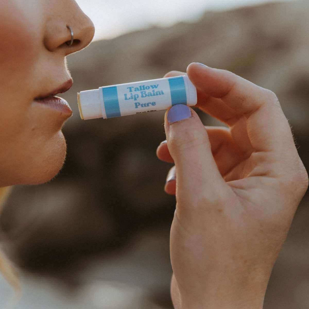 Naturallow Tallow Lip Balm, woman applying the Pure tube to her lips