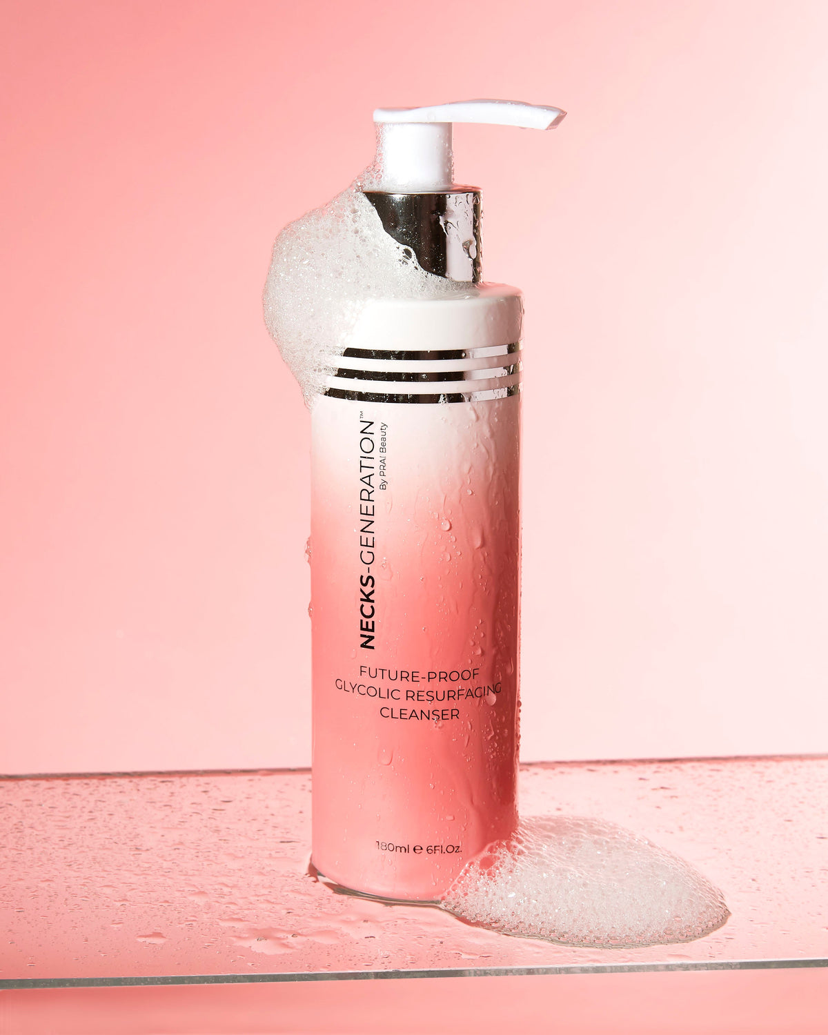 PRAI Beauty Necks-Generation Future-Proof Glycolic Resurfacing Cleanser, pump bottle with foam on a pink background