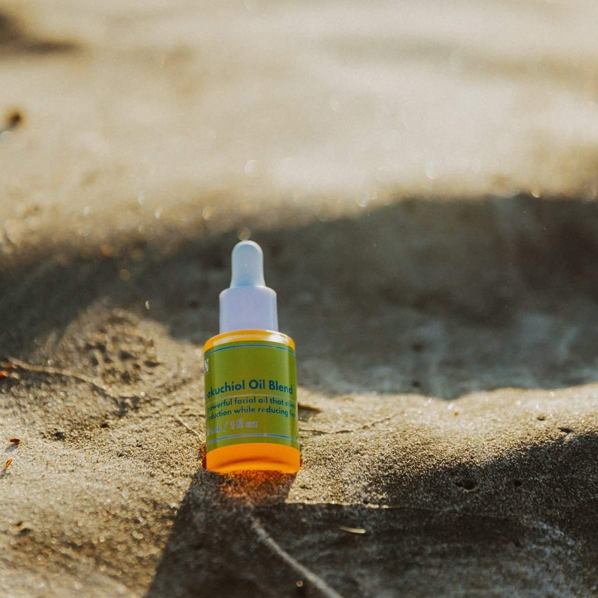 Naturallow Bakuchiol Facial Oil, dropper bottle standing in the sand