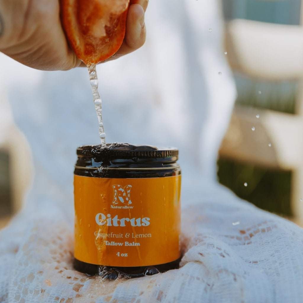Naturallow Tallow Body Balm, Citrus jar with an orange squeezed above it