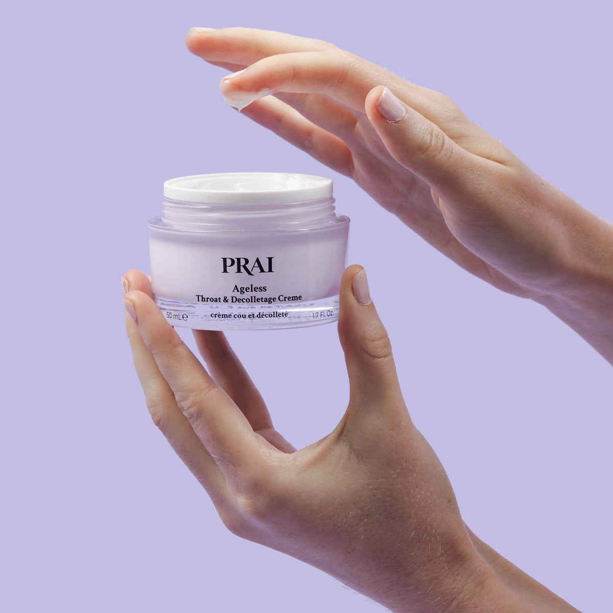 PRAI Beauty Neck & Décolletage Routine, hands holding an open jar of the creme